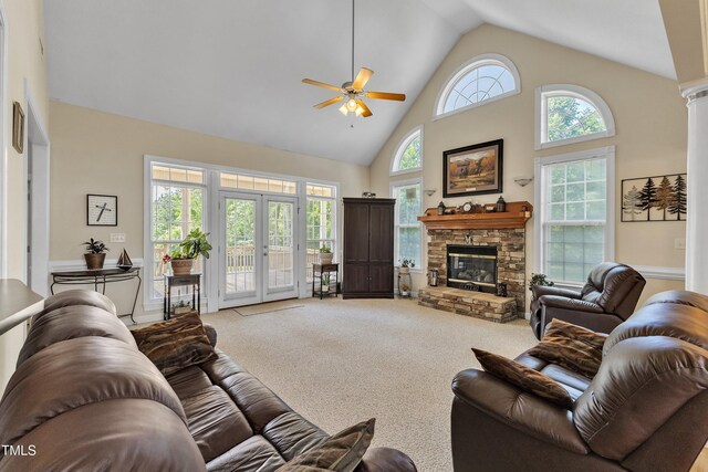 living area featuring carpet floors, a stone fireplace, ceiling fan, high vaulted ceiling, and french doors