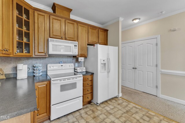 kitchen with crown molding, dark countertops, white appliances, glass insert cabinets, and brown cabinets