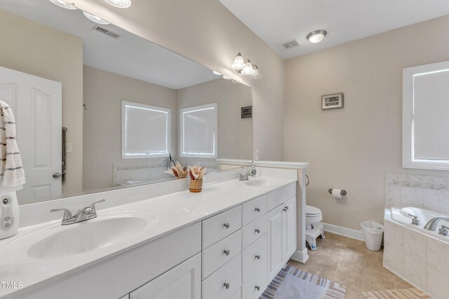 bathroom with visible vents, double vanity, a bath, tile patterned floors, and a sink