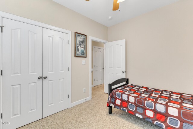 carpeted bedroom featuring a ceiling fan, baseboards, and a closet