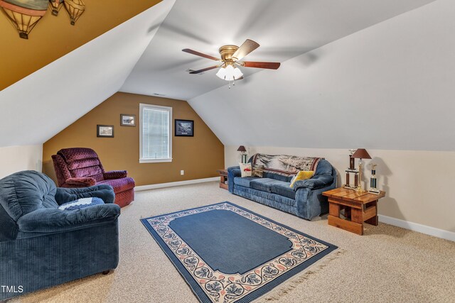 carpeted living area with baseboards, a ceiling fan, and vaulted ceiling