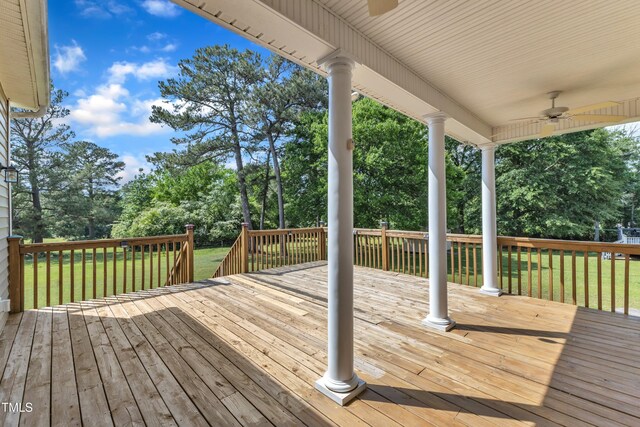 wooden deck featuring ceiling fan and a yard