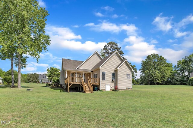 rear view of property with a lawn and stairway