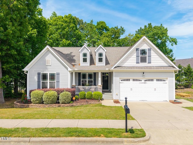 cape cod house featuring a garage, a front lawn, covered porch, roof with shingles, and concrete driveway