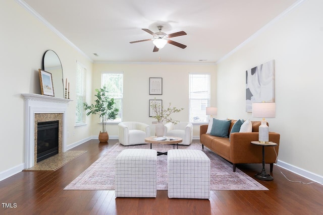 living area with wood-type flooring, a ceiling fan, plenty of natural light, and ornamental molding