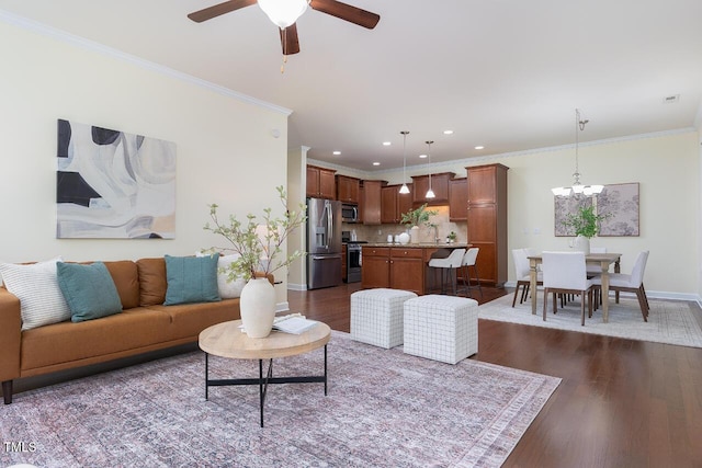 living area with baseboards, ornamental molding, dark wood-style flooring, and ceiling fan with notable chandelier