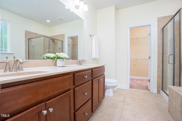 bathroom with tile patterned floors, a shower stall, and a sink