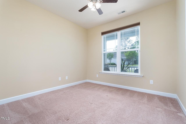 empty room with visible vents, carpet flooring, baseboards, and ceiling fan