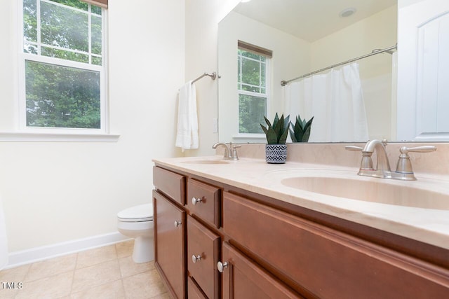 full bath with a sink, baseboards, toilet, and double vanity