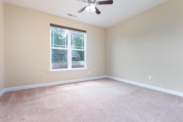 spare room featuring carpet floors, a ceiling fan, baseboards, and visible vents