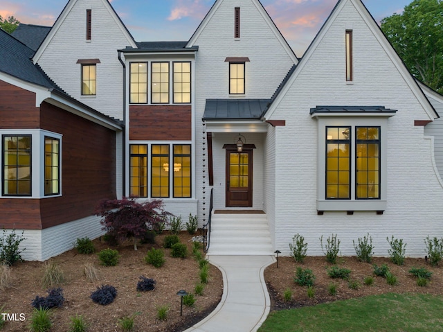 view of front of house with brick siding and a standing seam roof