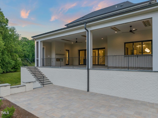 back of property at dusk featuring stairway, a patio, and ceiling fan