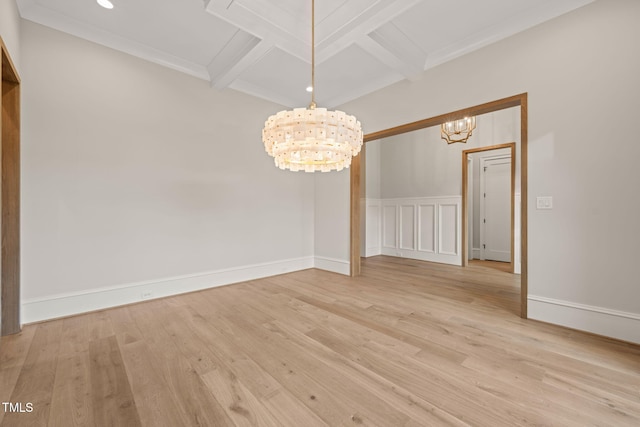 unfurnished dining area with beamed ceiling, a chandelier, light wood finished floors, and coffered ceiling