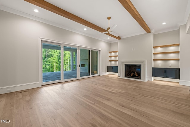 unfurnished living room featuring a fireplace with flush hearth, beamed ceiling, light wood-style floors, built in shelves, and a ceiling fan