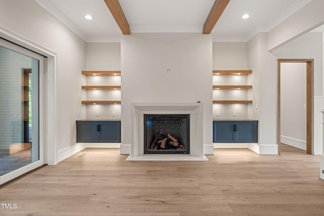 unfurnished living room featuring light wood-type flooring, built in features, a fireplace, and beamed ceiling
