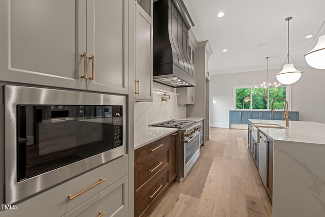 kitchen featuring range with two ovens, built in microwave, premium range hood, recessed lighting, and light wood-style flooring