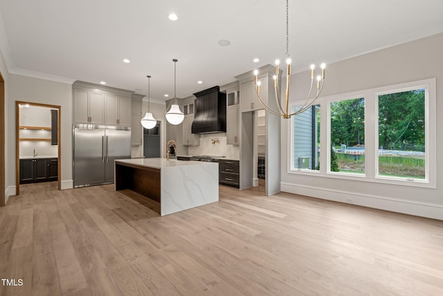 kitchen featuring stainless steel built in fridge, premium range hood, tasteful backsplash, and light wood finished floors