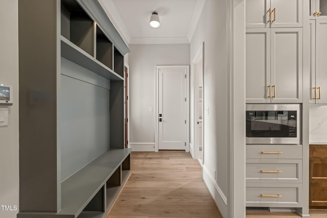 mudroom with crown molding, baseboards, and light wood finished floors