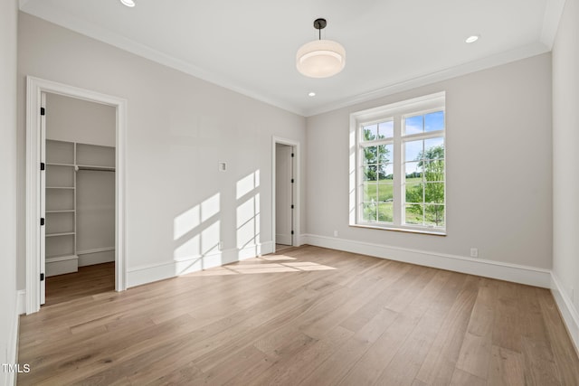 unfurnished bedroom featuring baseboards, ornamental molding, and light wood-style flooring
