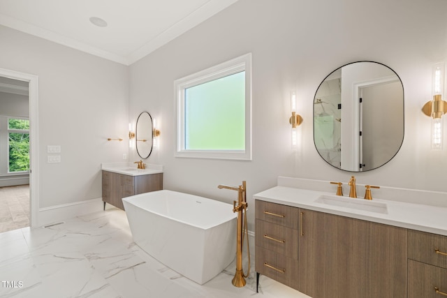 full bath featuring a sink, a freestanding tub, marble finish floor, and two vanities