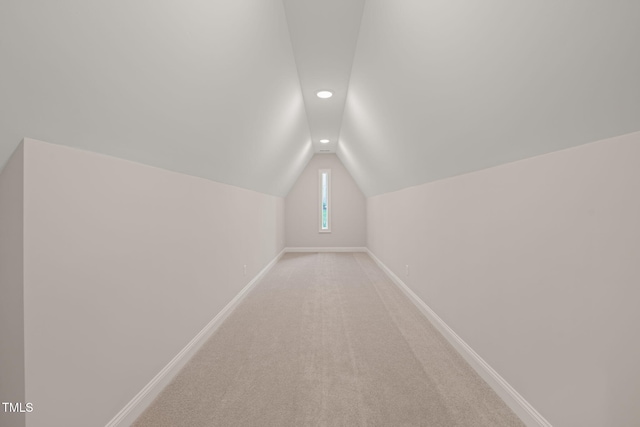 additional living space featuring baseboards, vaulted ceiling, recessed lighting, and light colored carpet