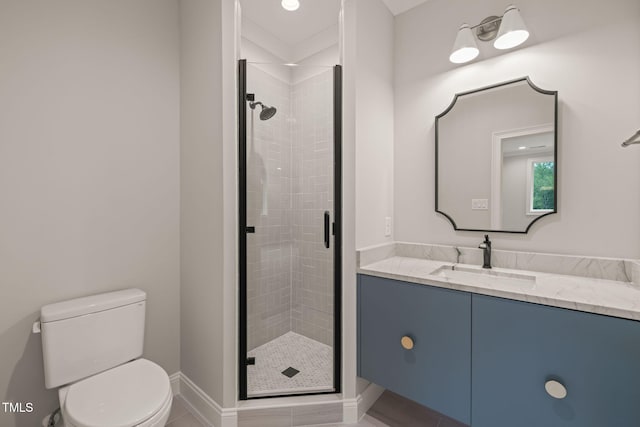 full bathroom with baseboards, vanity, toilet, and a shower stall