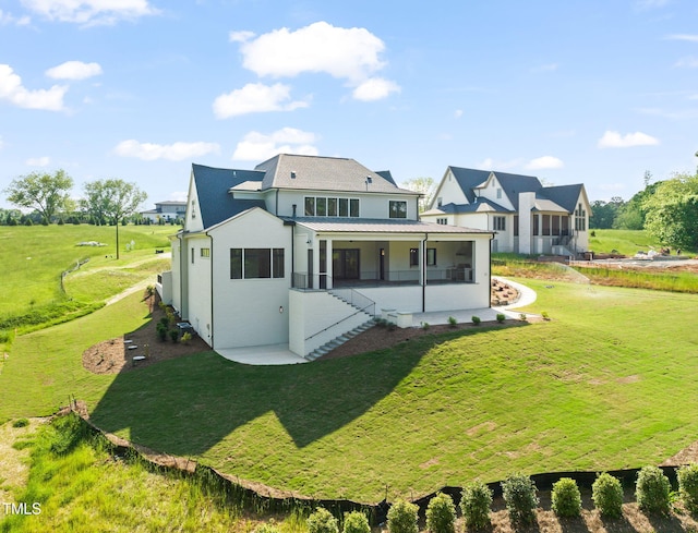 rear view of house with a lawn, stucco siding, a porch, and stairway