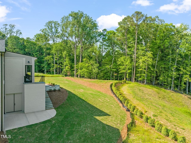 view of yard with a patio and a forest view