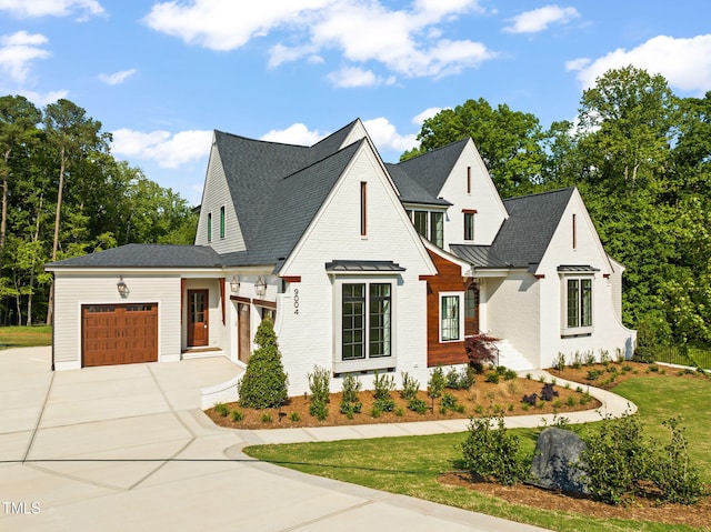 modern farmhouse style home featuring a garage, roof with shingles, driveway, and a front lawn