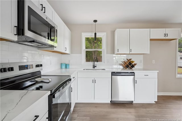 11504 Bissette Rd, Middlesex, NC 27557 - kitchen featuring a sink, stainless steel appliances, white cabinetry, light wood-style floors, and tasteful backsplash