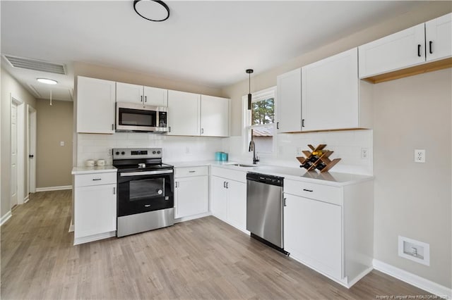 11504 Bissette Rd, Middlesex, NC 27557 - kitchen with light wood finished floors, a sink, stainless steel appliances, visible vents, and decorative backsplash