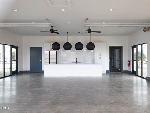 garage with ceiling fan, a sink, baseboards, freestanding refrigerator, and recessed lighting