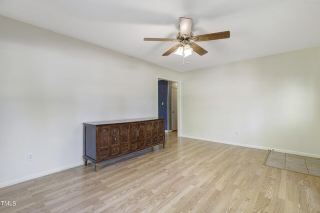 empty room featuring baseboards, ceiling fan, and wood finished floors