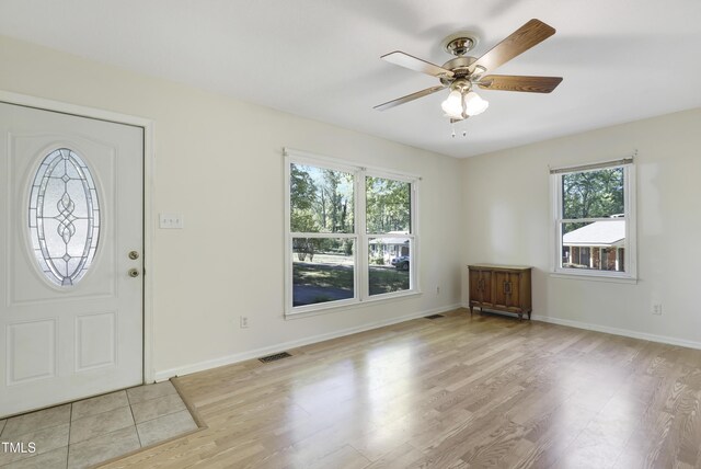 entrance foyer with a ceiling fan, baseboards, visible vents, and wood finished floors