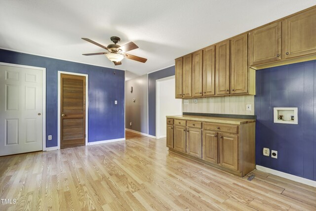 kitchen featuring baseboards, light wood-style flooring, ceiling fan, and brown cabinets