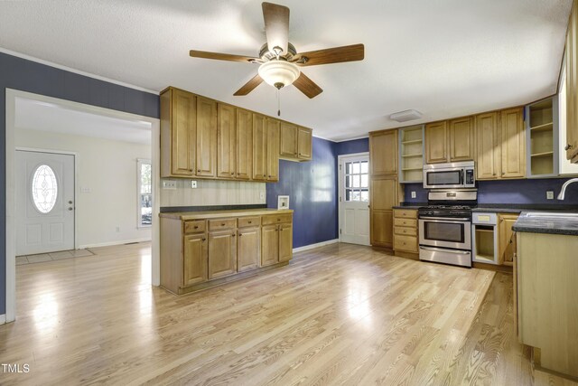 kitchen with open shelves, appliances with stainless steel finishes, dark countertops, and light wood-type flooring