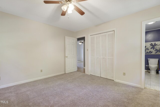 unfurnished bedroom with carpet floors, baseboards, a closet, and connected bathroom