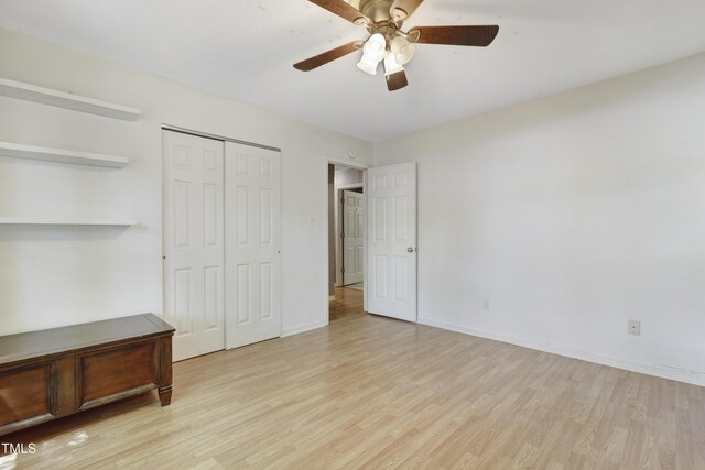 unfurnished bedroom featuring a closet, baseboards, ceiling fan, and wood finished floors