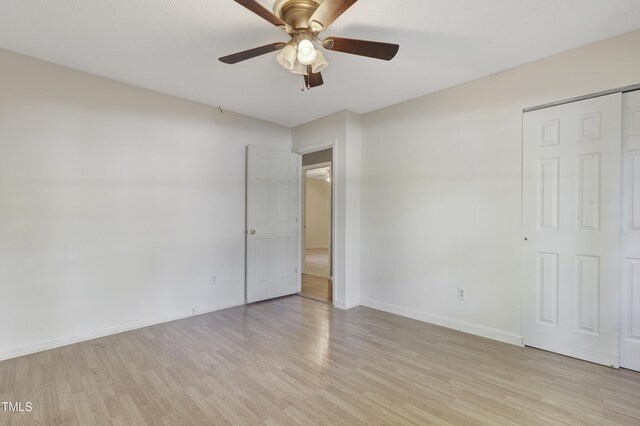 unfurnished bedroom with a ceiling fan, baseboards, and light wood-style flooring