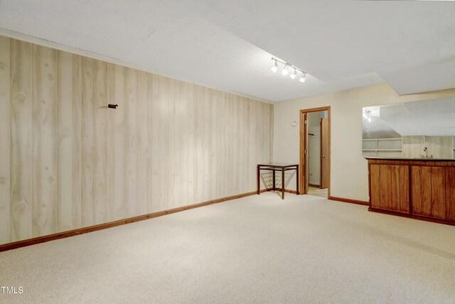interior space with carpet flooring, baseboards, and track lighting