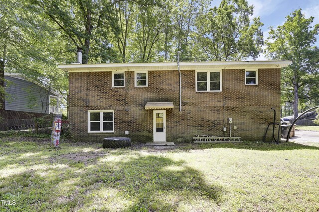 view of front facade with brick siding and a front yard