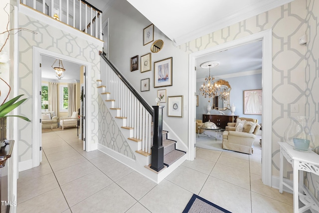 staircase with crown molding, wallpapered walls, a notable chandelier, and tile patterned flooring