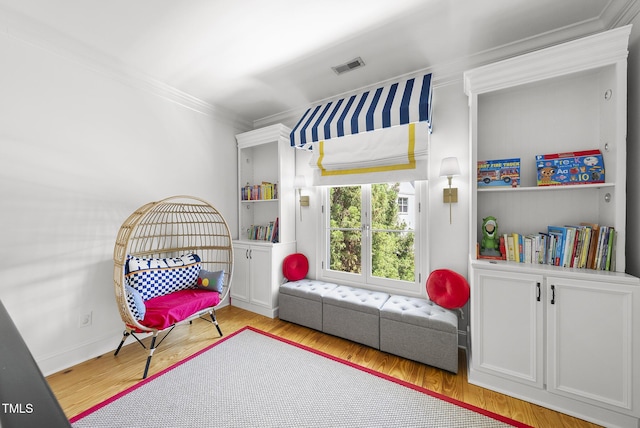 game room with visible vents, ornamental molding, baseboards, and wood finished floors