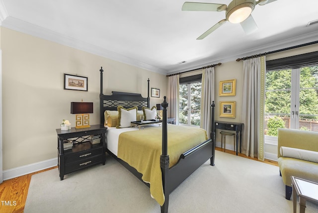 bedroom with crown molding, visible vents, baseboards, ceiling fan, and light wood-style flooring