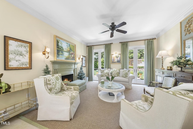 living area with ornamental molding, ceiling fan, carpet, and a warm lit fireplace