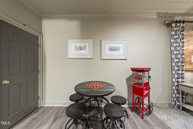 interior space featuring baseboards, ornamental molding, and wood finished floors