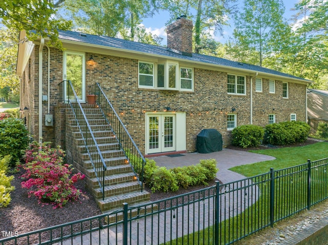 3420 Sheridan Dr, Durham, NC 27707 - view of front of home with stairway, a patio, a chimney, a fenced backyard, and brick siding
