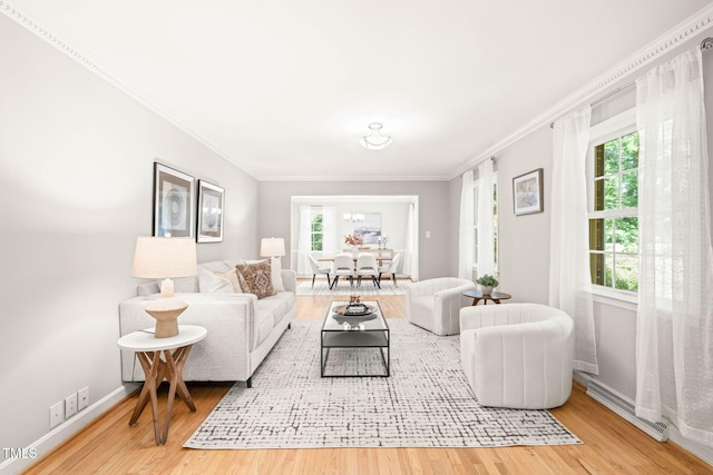 3420 Sheridan Dr, Durham, NC 27707 - living room with ornamental molding, wood finished floors, baseboards, and a chandelier