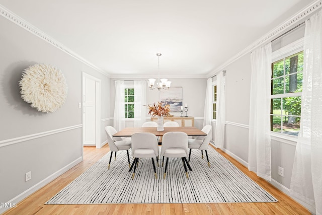 3420 Sheridan Dr, Durham, NC 27707 - dining area with a chandelier, light wood-style floors, crown molding, and baseboards