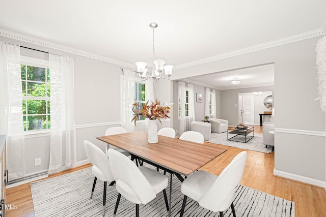 3420 Sheridan Dr, Durham, NC 27707 - dining space with a chandelier, light wood-style flooring, crown molding, and baseboards